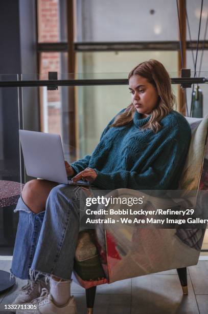 thoughtful moment for a young woman working from her laptop - native australian plants stock-fotos und bilder