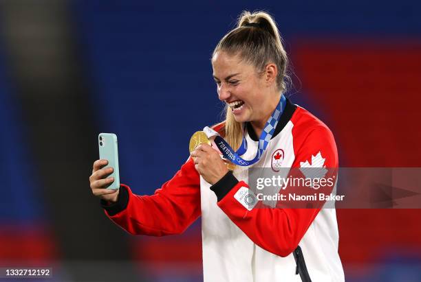 Gold medalist Janine Beckie of Team Canada poses with her gold medal during the Women's Football Competition Medal Ceremony on day fourteen of the...