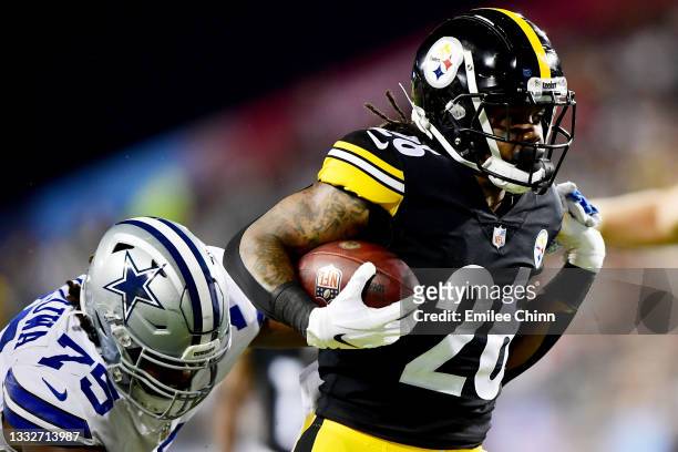 Anthony McFarland of the Pittsburgh Steelers runs the ball past Osa Odighizuwa of the Dallas Cowboys during the 2021 NFL preseason Hall of Fame Game...