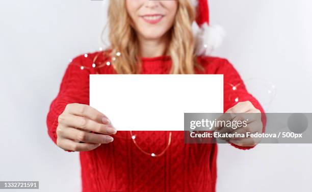 portrait of smiling woman holding blank placard against white background - happy santa claus over white blank stock-fotos und bilder