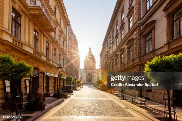 budapest street with st. stephen basilica in the center at sunrise, hungary - alley stock-fotos und bilder