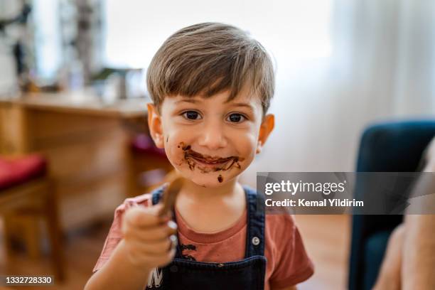 süßer kleiner junge genießt es, zu hause eis zu essen - cream mouth stock-fotos und bilder