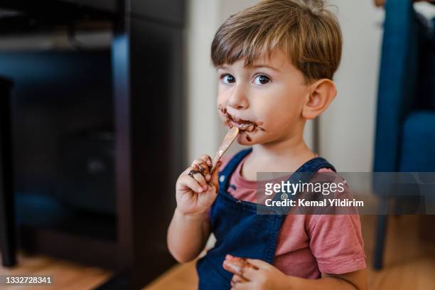かわいい男の子は自宅でアイスクリームを食べて楽しむ - chocolate eating ストックフォトと画像