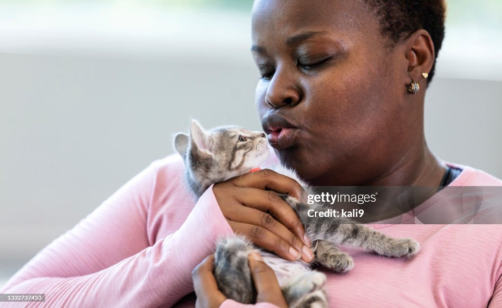 African-American woman kissing a kitten