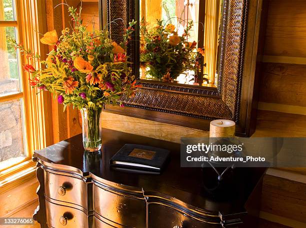 foyer table at home entrance with flowers and guest book - gastenboek stockfoto's en -beelden