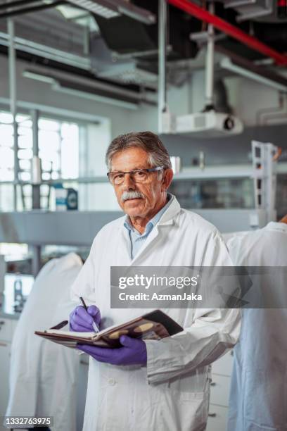 senior university professor in lab with personal organizer - purple glove stock pictures, royalty-free photos & images