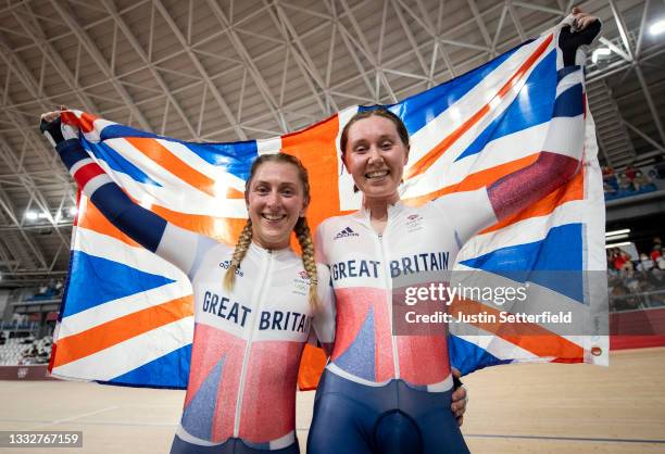 Laura Kenny and Katie Archibald of Team Great Britain celebrate winning a gold medal while holding the flag of their country during the Women's...