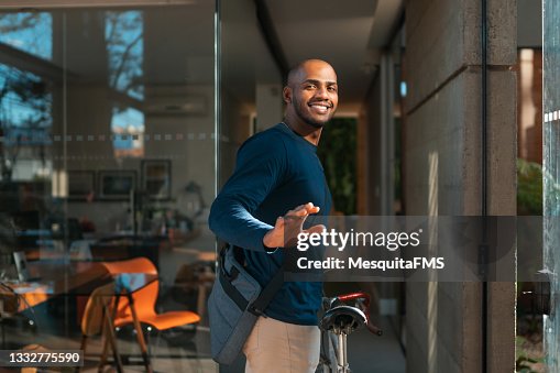 Jeune homme arrivant à vélo sur le lieu de travail Jeune homme arrivant à vélo sur le lieu de travail