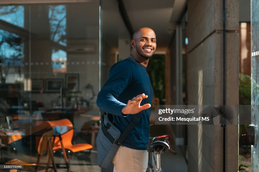 Young man arriving by bicycle at the workplace