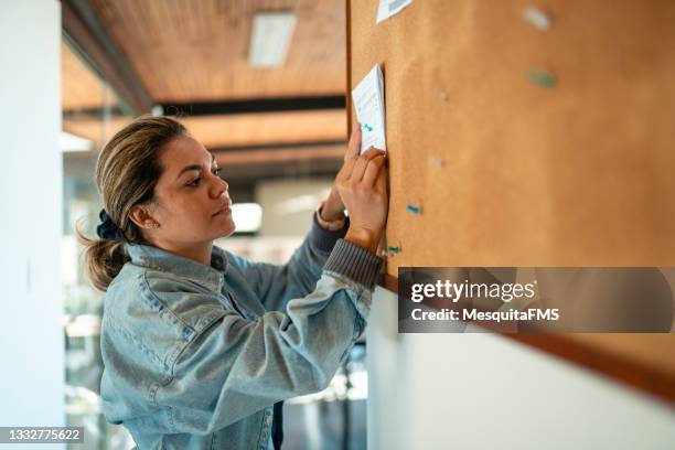 mujer de negocios que trabaja en el tablón de anuncios - tablón de anuncios fotografías e imágenes de stock