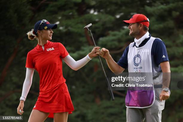 Nelly Korda of Team United States and caddie Jason McDede fist bump after making birdie on the 13th green during the final round of the Women's...