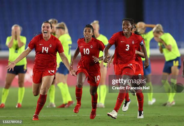 Vanessa Gilles, Ashley Lawrence and Kadeisha Buchanan of Team Canada celebrate following their team's victory in the penalty shoot out in the Women's...