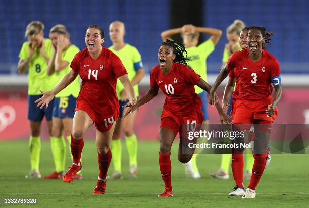 Vanessa Gilles, Ashley Lawrence and Kadeisha Buchanan of Team Canada celebrate following their team's victory in the penalty shoot out in the Women's...