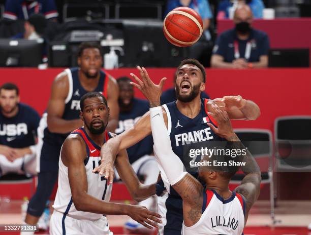 Rudy Gobert of Team France and Damian Lillard of Team United States compete for the ball as Kevin Durant looks on during the second half of a Men's...