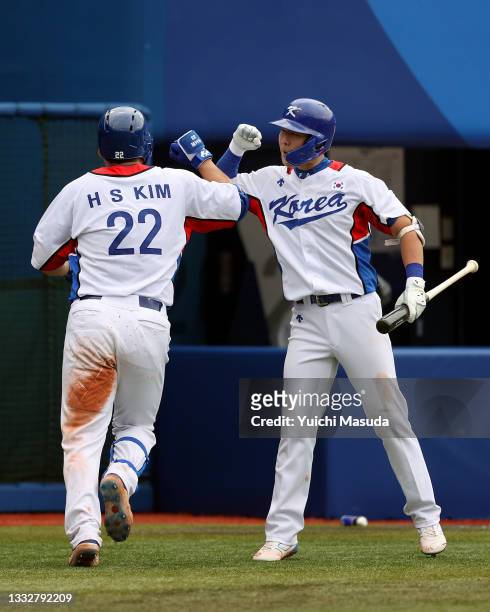 Outfielder Hyunsoo Kim of Team Republic of Korea elbow bumps with his team mate Outfielder Kunwoo Park hits a solo home run in the fourth inning...