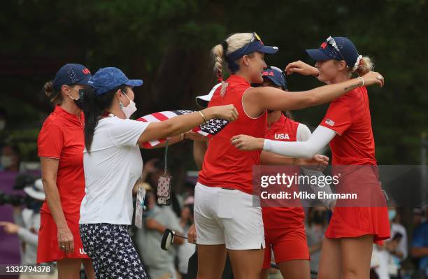 Nelly Korda of Team United States celebrates her gold-medal win with Lexi Thompson and other members of Team United States on the 18th green during...