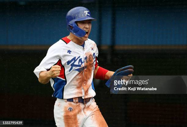 Outfielder Hae Min Park of Team Republic of Korea celebrates scoring a run after the wild pitch of Pitcher Dario Alvarez of Team Dominican Republic...