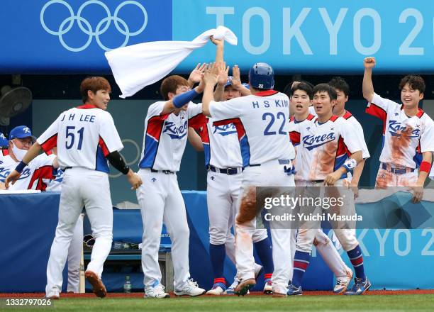 Outfielder Hyunsoo Kim of Team Republic of Korea celebrates scoring a run with his team mates after the RBI single of Designated hitter Baekho Kang...