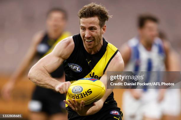 Kane Lambert of the Tigers handballs during the round 21 AFL match between Richmond Tigers and North Melbourne Kangaroos at Melbourne Cricket Ground...