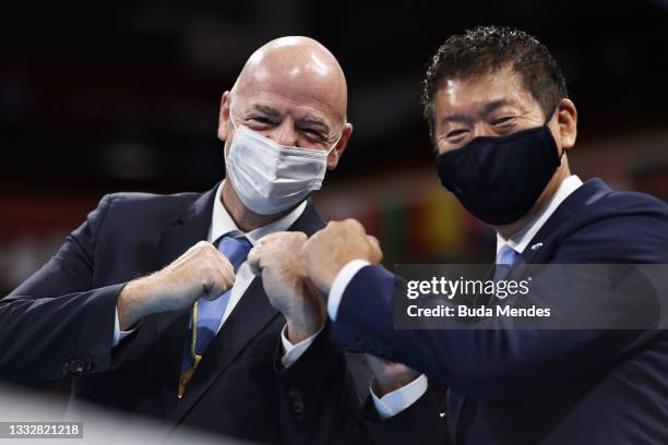 Gianni Infantino, FIFA President fist bumps Katsuaki Watanabe, IOC member during the medal ceremony on day fifteen of the Tokyo 2020 Olympic Games at...