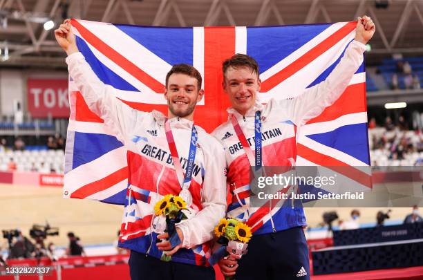 Silver medalists Matthew Walls and Ethan Hayter of Team Great Britain, pose on the podium while holding the flag of they country during the medal...