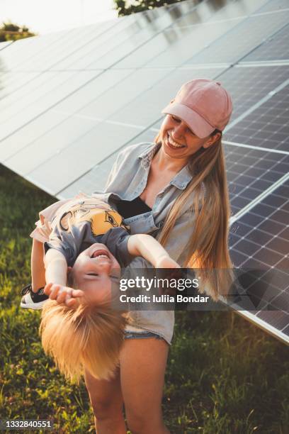 mother and son playing by solar panels - solar panel home stock pictures, royalty-free photos & images