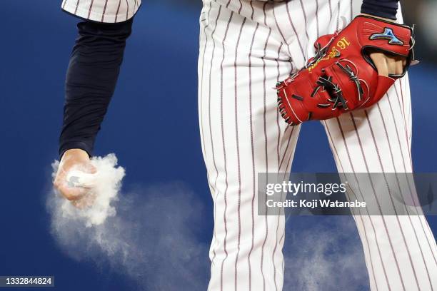 Pitcher Hiromi Ito of Team Japan tosses a rosin bag before the seventh inning against Team United States during the gold medal game between Team...