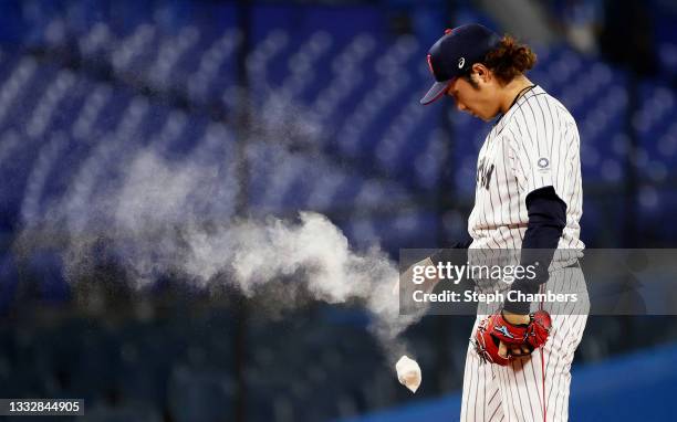 Pitcher Hiromi Ito of Team Japan tosses a rosin bag during the seventh inning against Team United States during the gold medal game between Team...