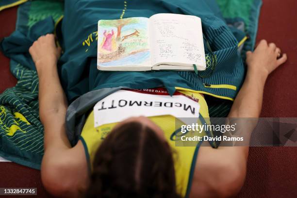 Nicola McDermott of Team Australia reads her journal as she competes in the Women's High Jump Final on day fifteen of the Tokyo 2020 Olympic Games at...