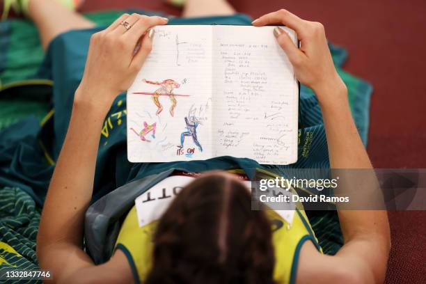Nicola McDermott of Team Australia reads her journal as she competes in the Women's High Jump Final on day fifteen of the Tokyo 2020 Olympic Games at...