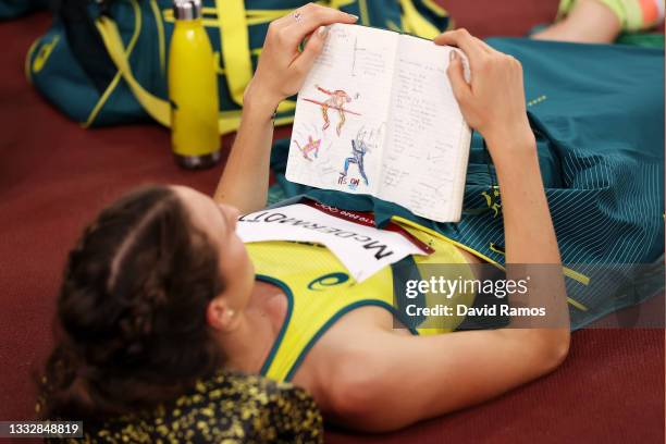 Nicola McDermott of Team Australia reads her journal as she competes in the Women's High Jump Final on day fifteen of the Tokyo 2020 Olympic Games at...