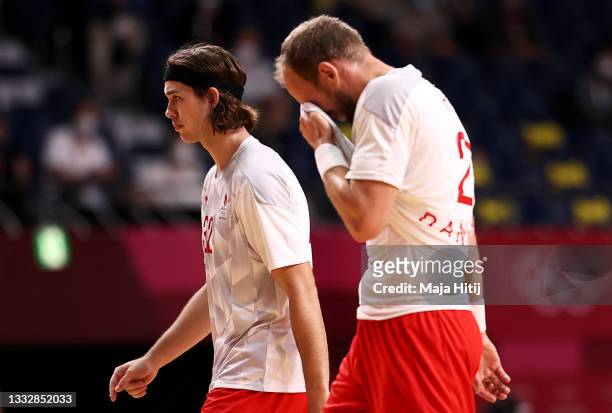 Jacob Holm and Henrik Toft Hansen of Team Denmark leave the field of play for halftime of the Men's Gold Medal handball match between France and...