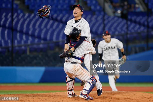 Catcher Takuya Kai and Pitcher Ryoji Kuribayashi of Team Japan celebrate winning the gold after their 2-0 victory over Team United States in the gold...