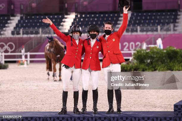 Silver medalists Laura Kraut, Jessica Springsteen and McLain Ward of Team United States celebrate on the podium during the Jumping Team Final medal...