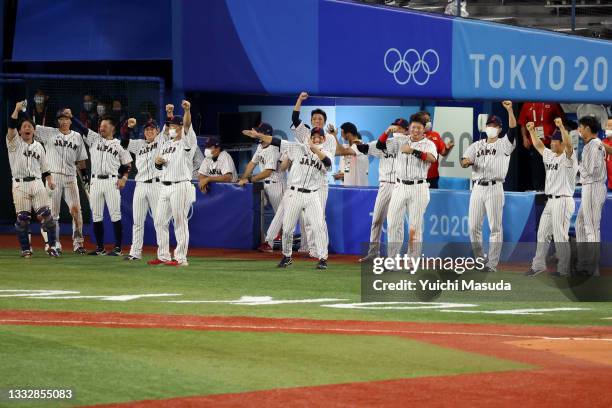 Players of Team Japan celebrate as designated hitter Tetsuto Yamada of Team Japan scores a run by the throwing error of Outfielder Jack Lopez of Team...