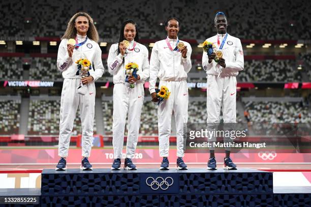 Gold medalists Allyson Felix, Athing Mu, Dalilah Muhammad and Sydney McLaughlin of Team United States stand on the podium during the medal ceremony...