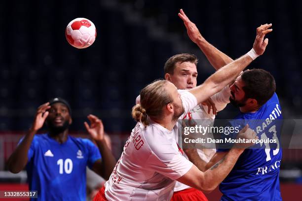 Nikola Karabatic of Team France passes the ball while under pressure from Henrik Moellgaard and Lasse Andersson of Team Denmark during the Men's Gold...