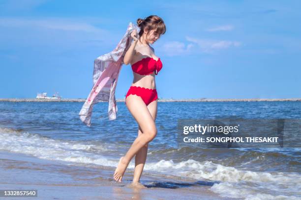 young tourists in bikinis on the beach by the sea - asian swimsuit models stock pictures, royalty-free photos & images