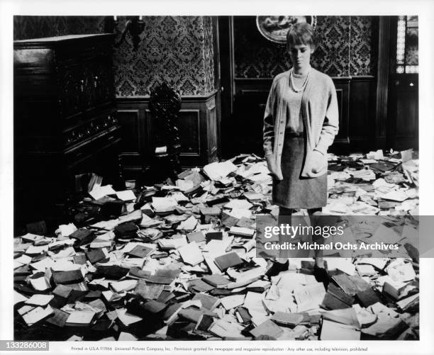 Julie Christie stands among torn books in a scene from the film Fahrenheit 451', 1966.