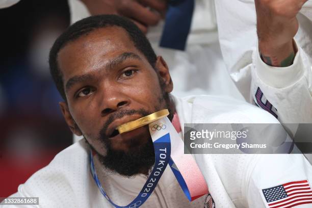 Kevin Durant of Team United States bites his gold medal as he poses for photographs during the Men's Basketball medal ceremony on day fifteen of the...