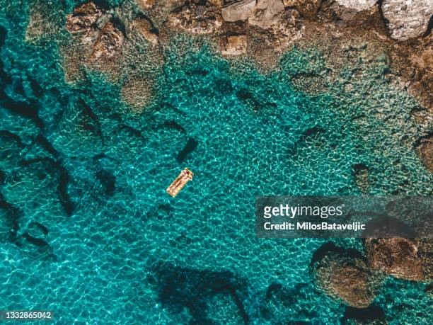 aerial view of woman enjoying in the water,ionian islands, greece - aerial beach view sunbathers stock pictures, royalty-free photos & images
