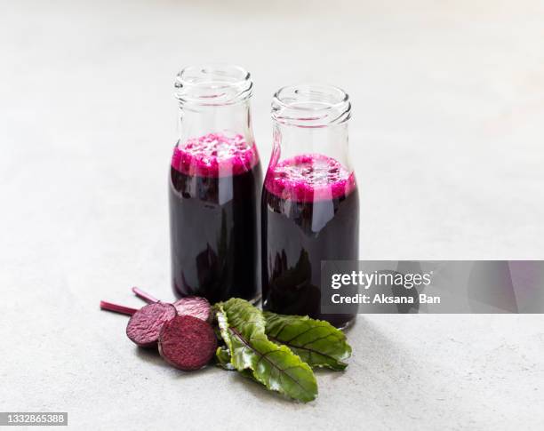 fresh beet juice in a glass bottle on a light gray background - beetroot smoothie stock pictures, royalty-free photos & images