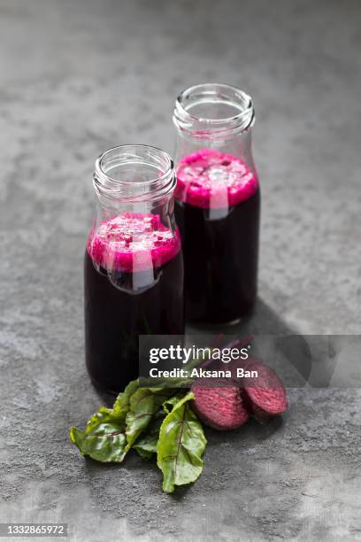 beetroot drink in a glass bottle on a dsrk gray background - beetroot juice stockfoto's en -beelden