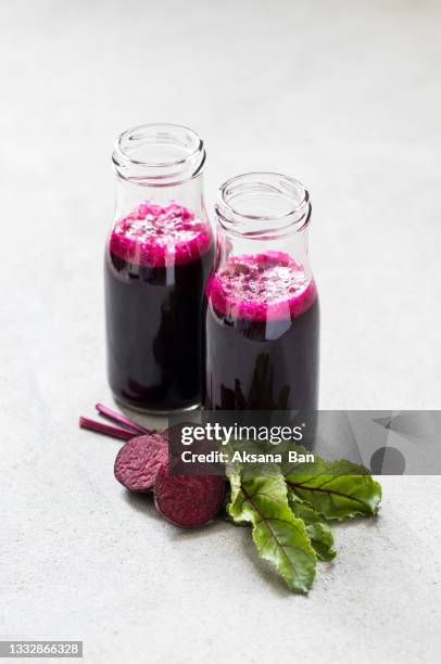 vegan drink made from fresh beetroot in a glass bottle on a light gray background - beetroot smoothie stock pictures, royalty-free photos & images