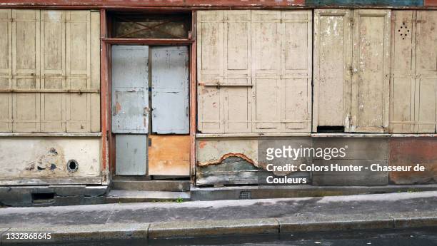 weathered facade of an abandoned store and street in paris - abandoned store stockfoto's en -beelden