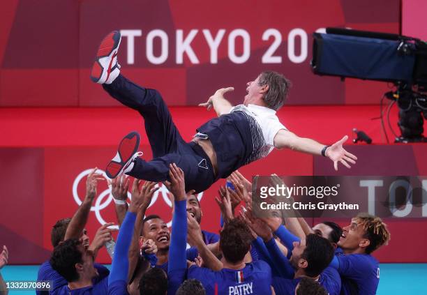 Players of Team France throw Head Coach Laurent Tillie into the air as they celebrate defeating Team ROC during the Men's Gold Medal Match on day...