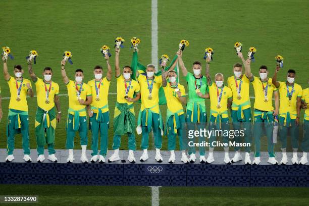 Gold medalists of Team Brazil celebrate with their gold medals on the podium during the Men's Football Competition Medal Ceremony on day fifteen of...
