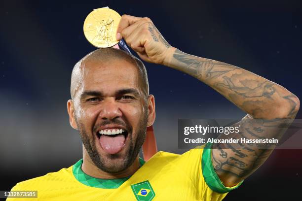 Gold medalist Dani Alves of Team Brazil celebrates with their gold medal during the Men's Football Competition Medal Ceremony on day fifteen of the...