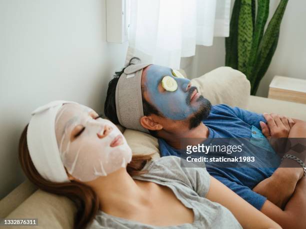 happy couple doing facial mask. - men facial stock pictures, royalty-free photos & images