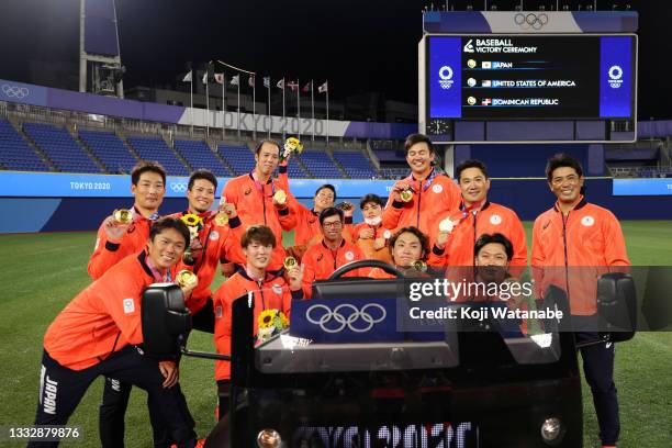 Players and staffs of Team Japan pose for photographs after the medal ceremony for baseball during the gold medal game between Team United States and...